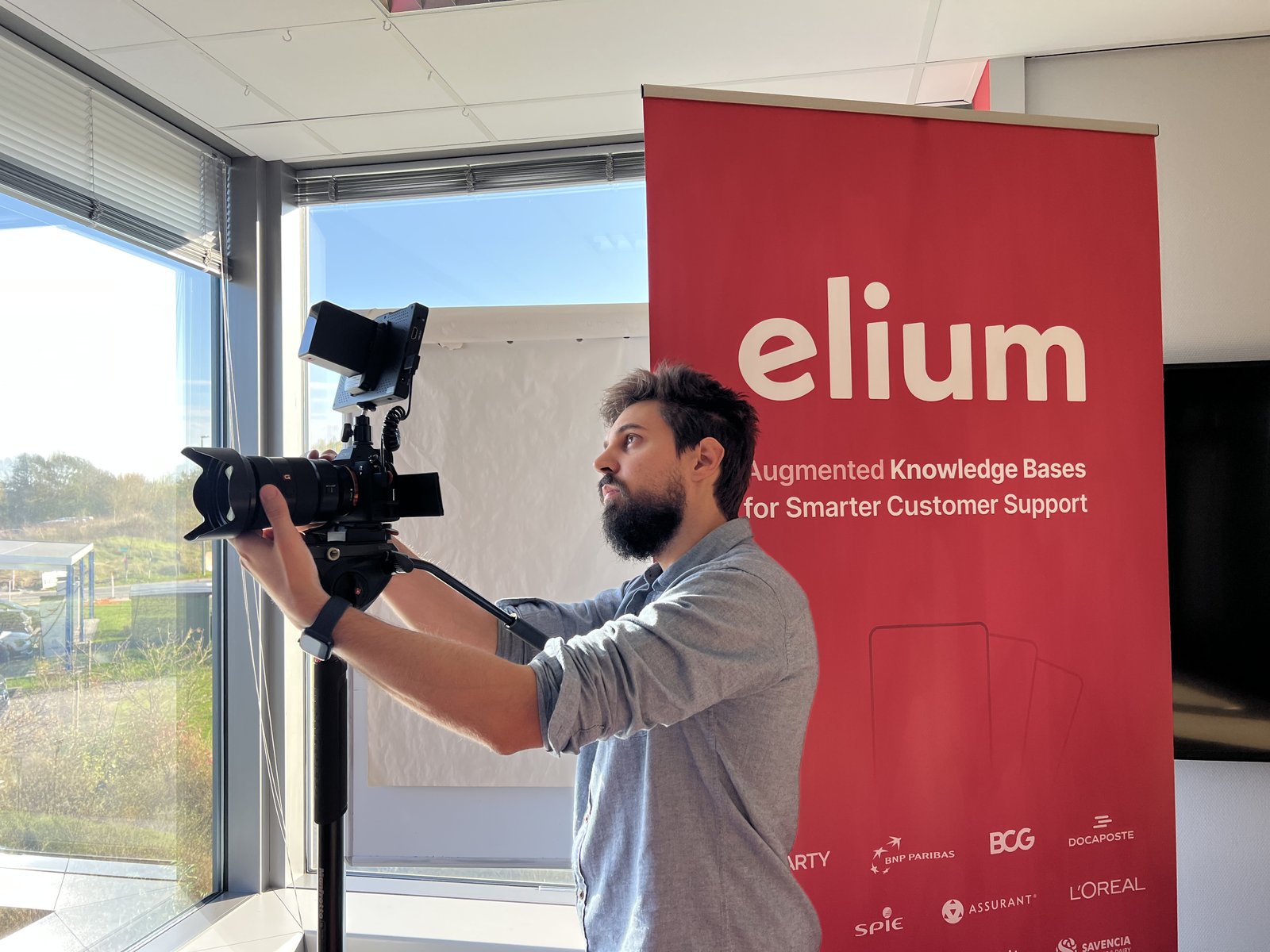 Filming a video in front of the Elium banner